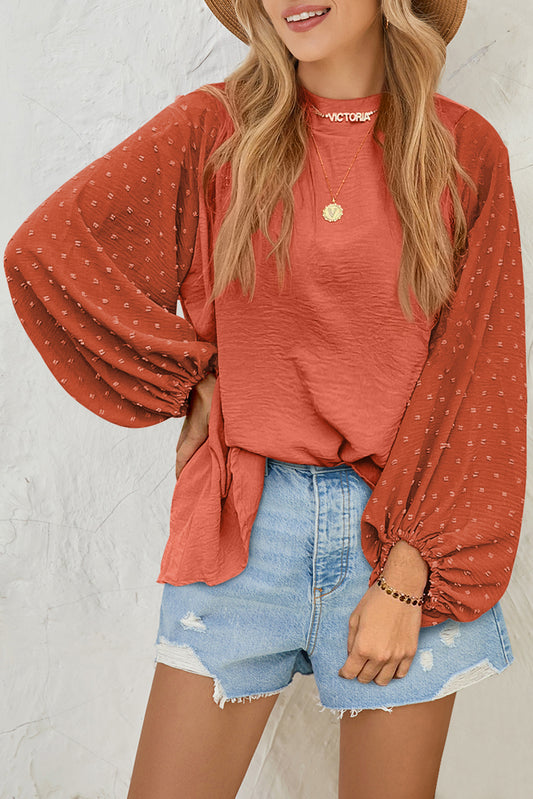Woman wearing a rust-colored long-sleeve top with a white background
