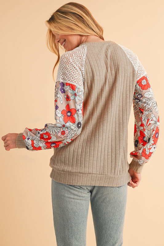 Woman wearing a beige sweater with floral sleeves on a beige background
