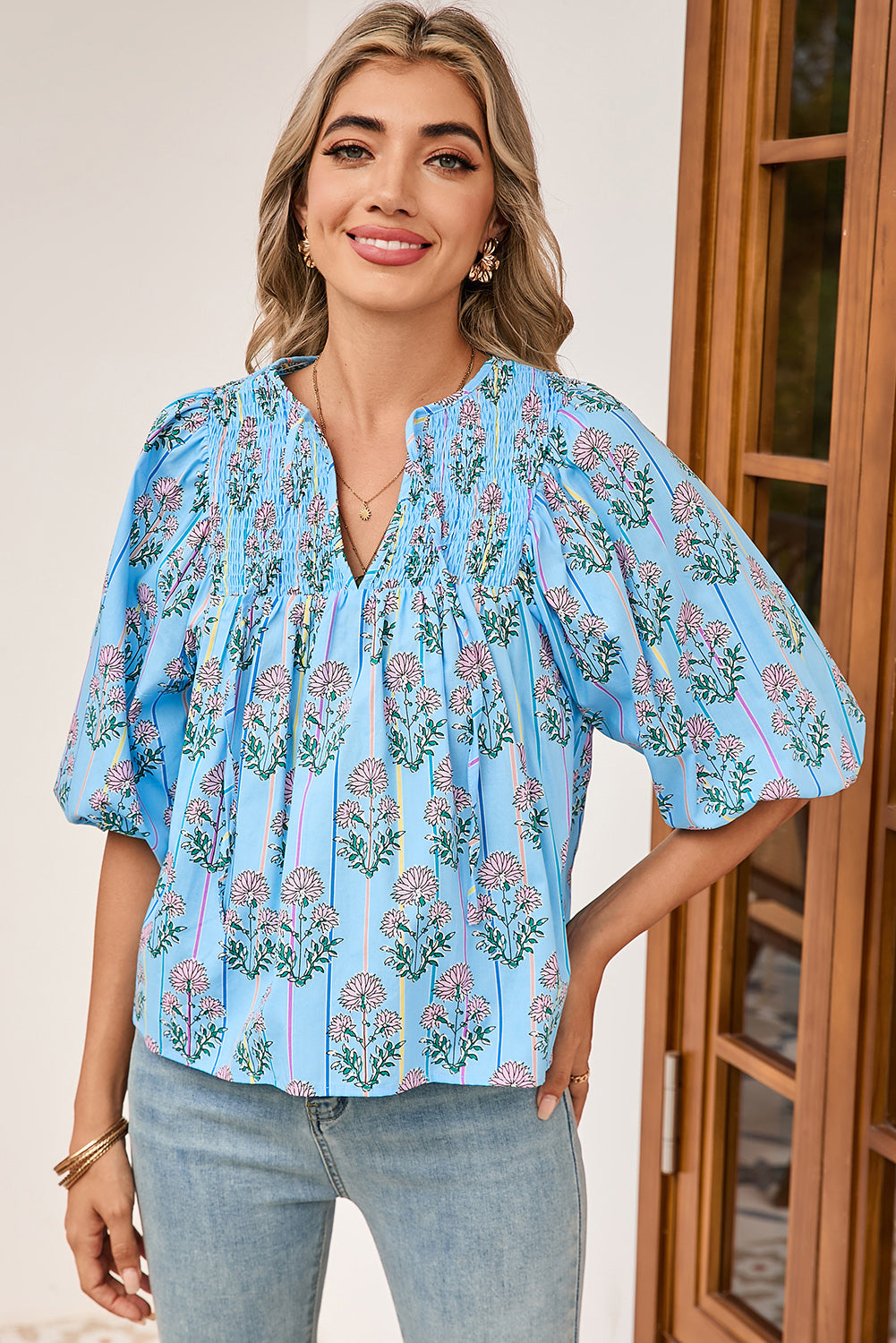 Woman wearing a blue floral blouse with a neutral background