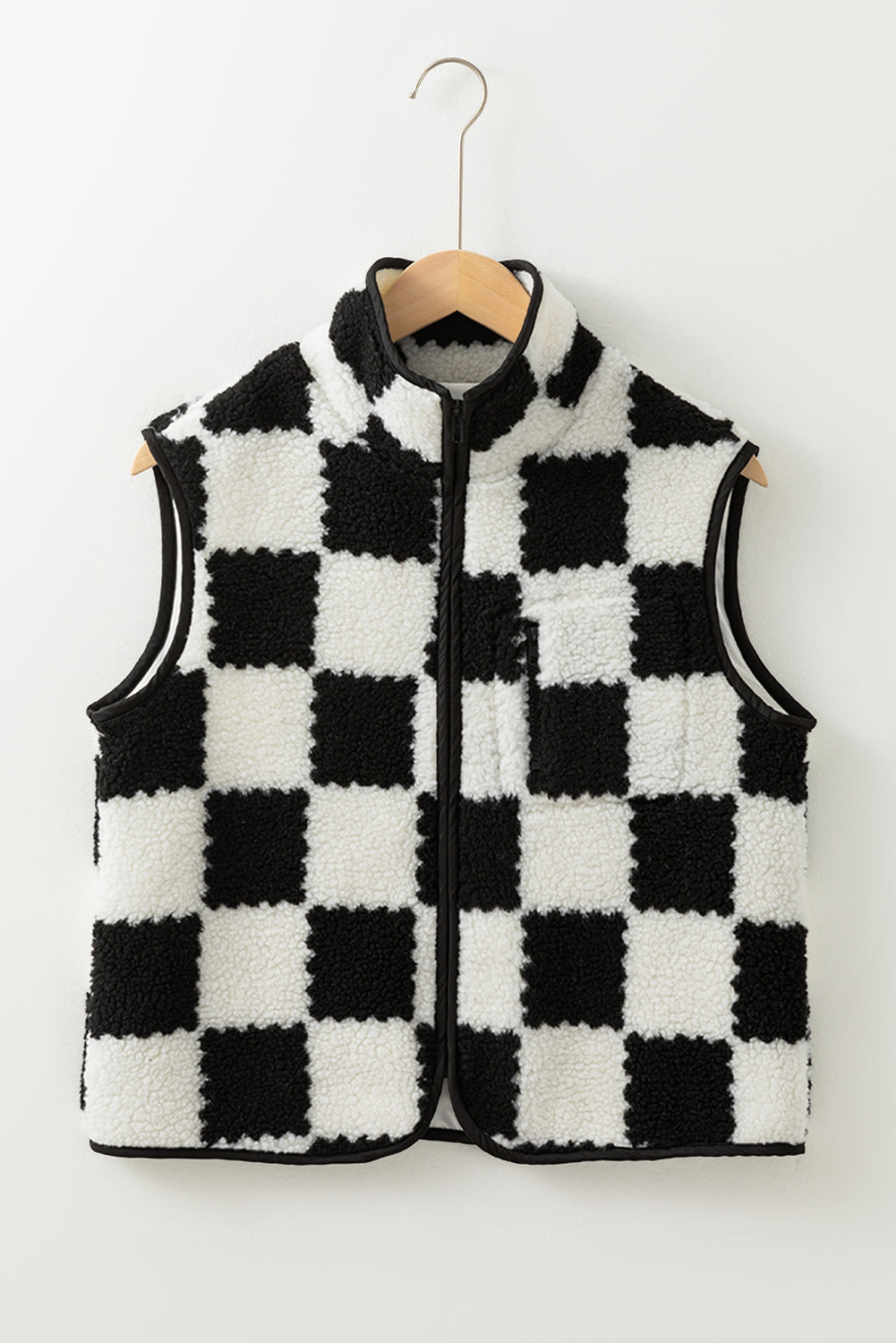 Black and white checkered vest on a hanger against a white background