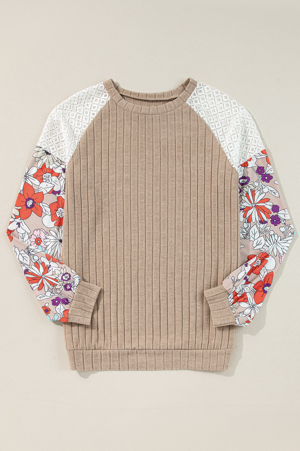 Beige sweater with floral-patterned sleeves on a beige background