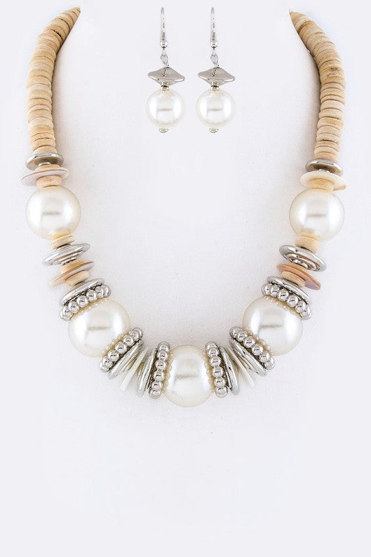 Necklace and earrings set with pearls and metallic accents on a white background
