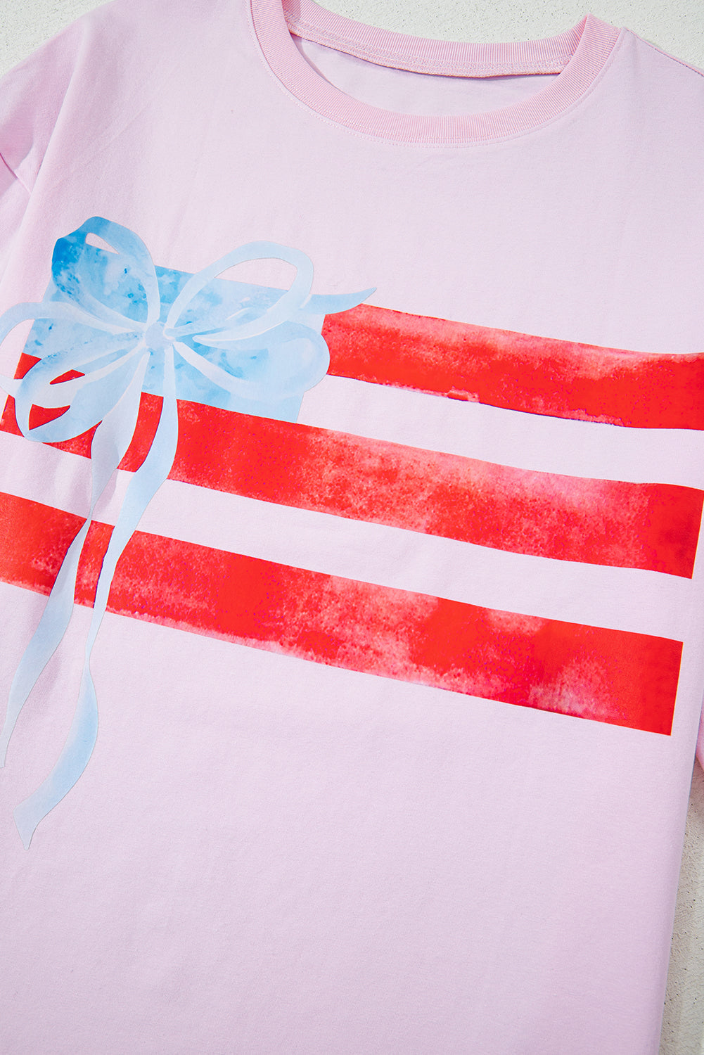 Pink shirt with red stripes and a blue bow on a light green background