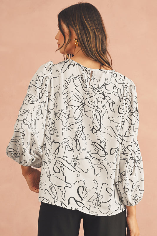 Woman wearing a white blouse with black abstract patterns on a beige background