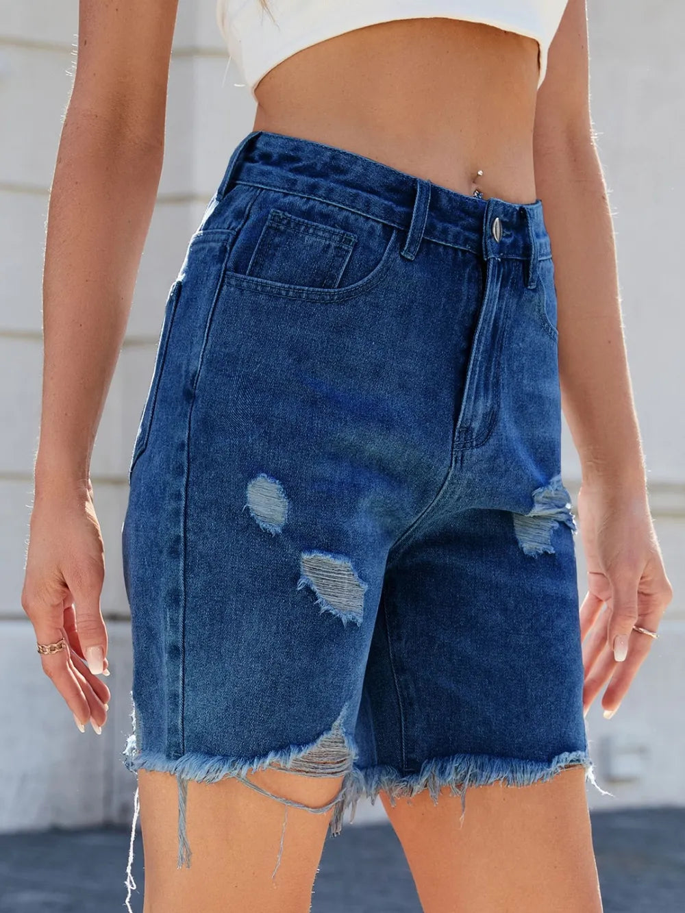 Person wearing blue denim shorts with a blurred background