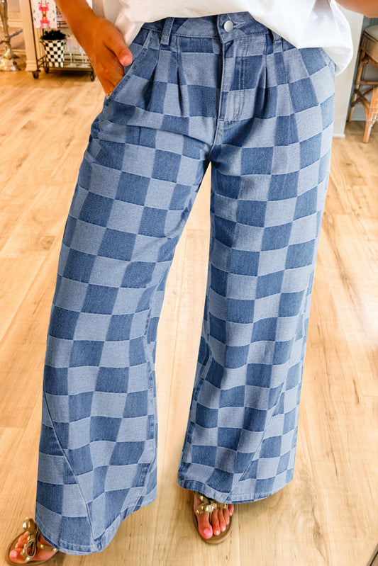 Blue checkered pants worn by a person on a wooden floor.