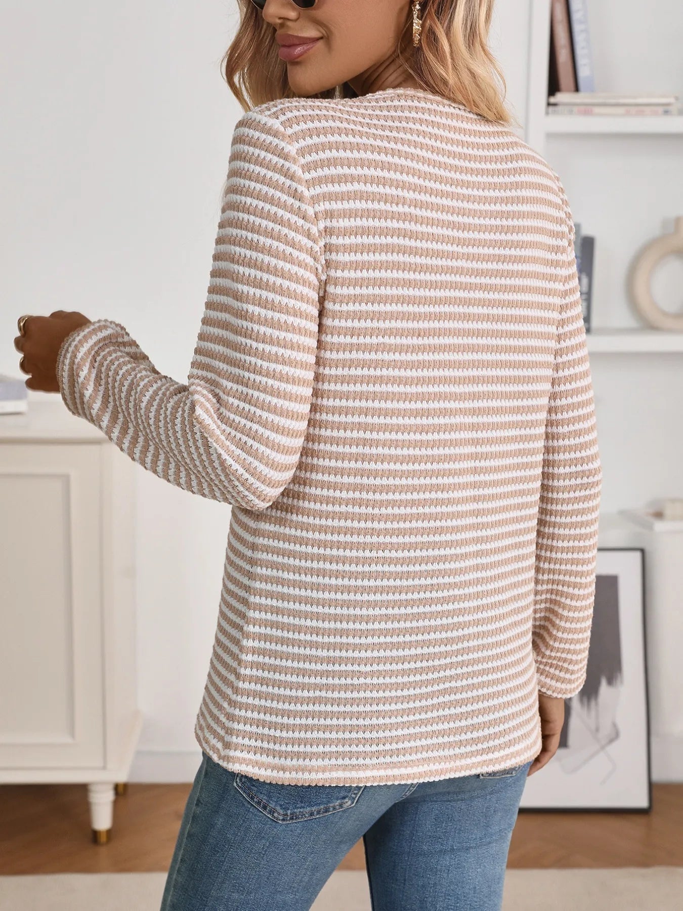 person wearing a long sleeve striped blouse