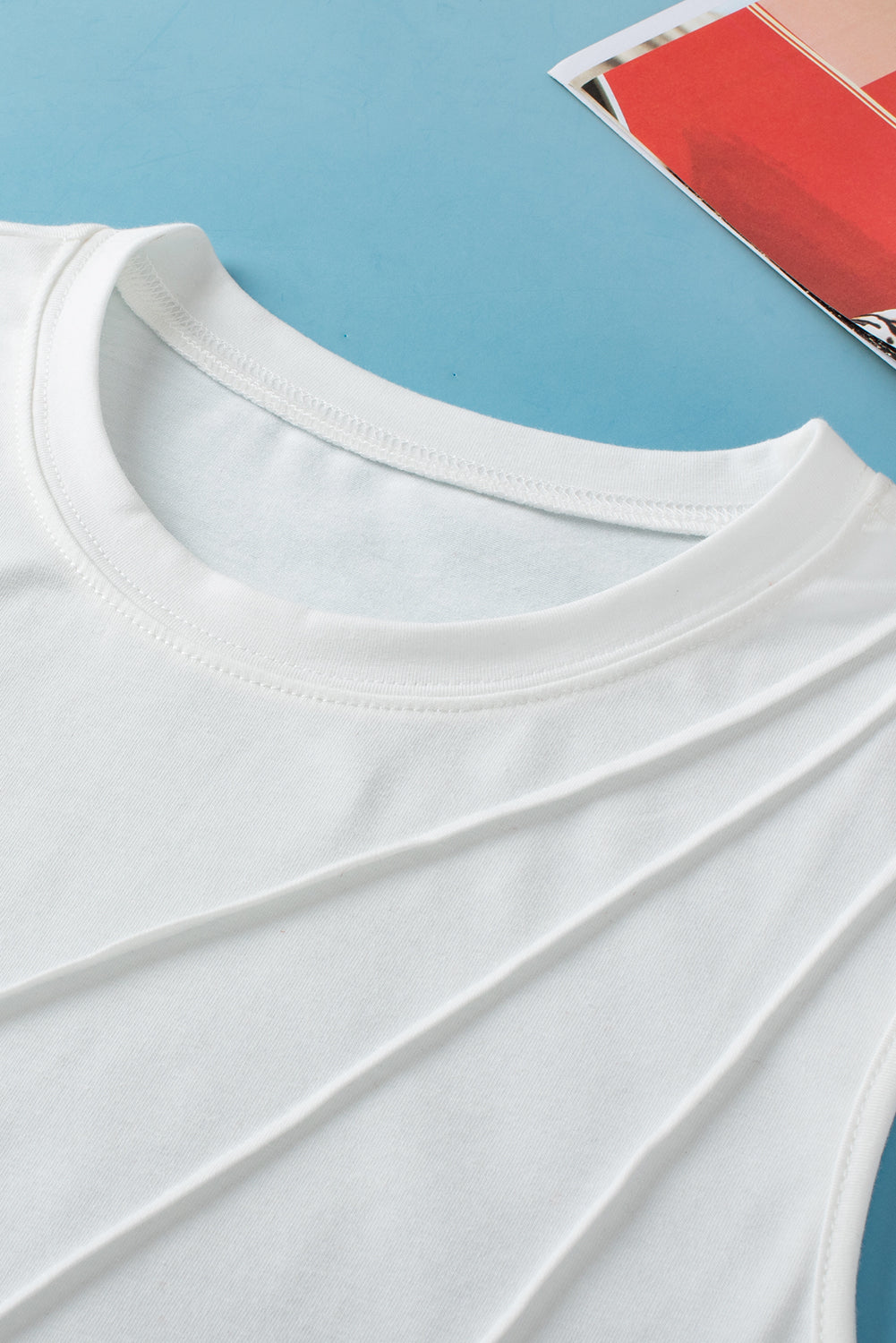 Close-up of a white t-shirt collar on a blue background