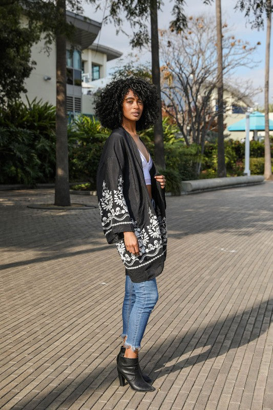 Woman wearing a black and white patterned cardigan in an outdoor setting
