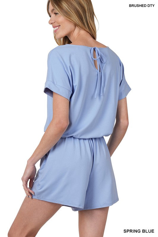 Woman wearing a light blue romper on a white background