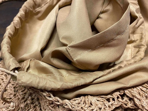 Close-up of a beige fabric with a textured surface on a woven mat.
