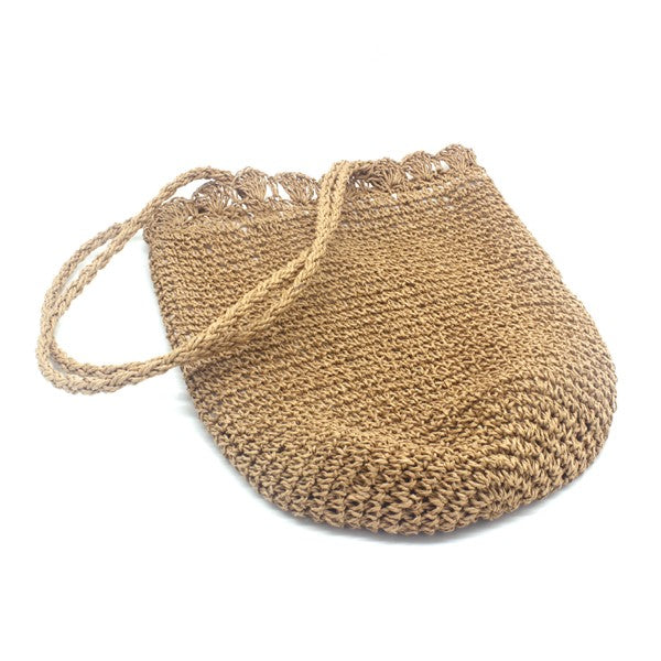 Woven straw bag with a handle on a white background