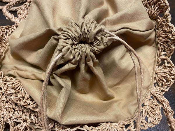 Beige drawstring bag on a textured surface