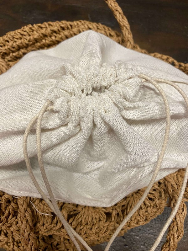 White drawstring bag on a textured brown surface