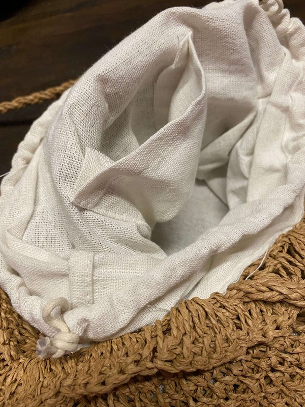 Close-up of a white fabric wrapped around a woven basket on a wooden surface