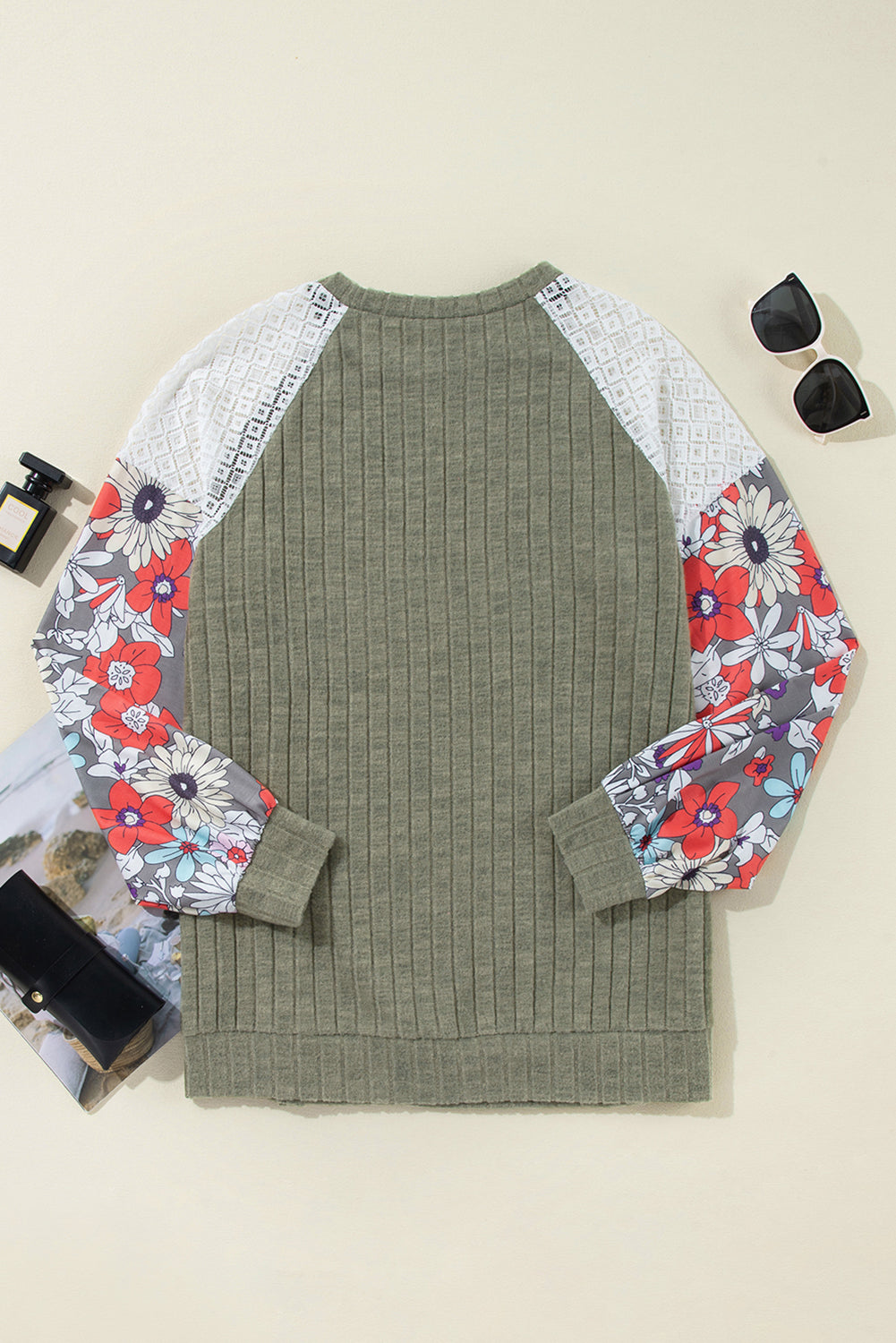 Green sweater with floral-patterned sleeves on a light background