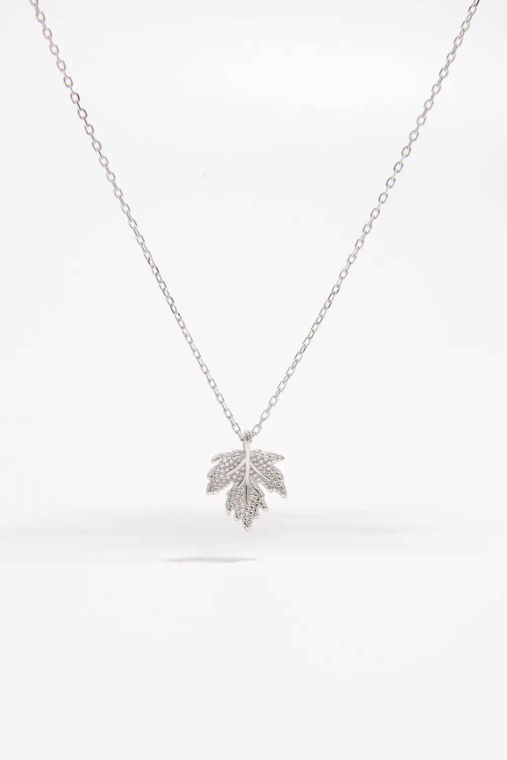 Silver leaf pendant necklace on a white background