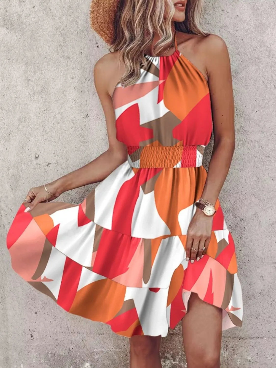 Woman wearing a colorful dress with a pattern against a plain background