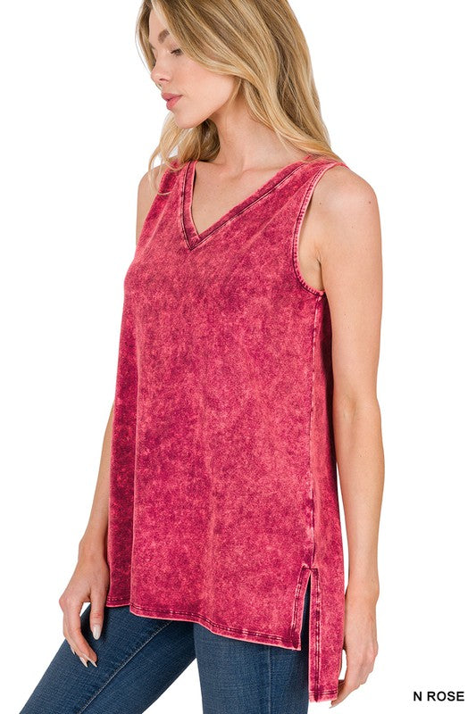 Woman wearing a red sleeveless top with a V-neck and side slits, standing against a white background.