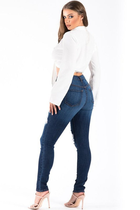 Woman wearing blue jeans and a white top on a white background