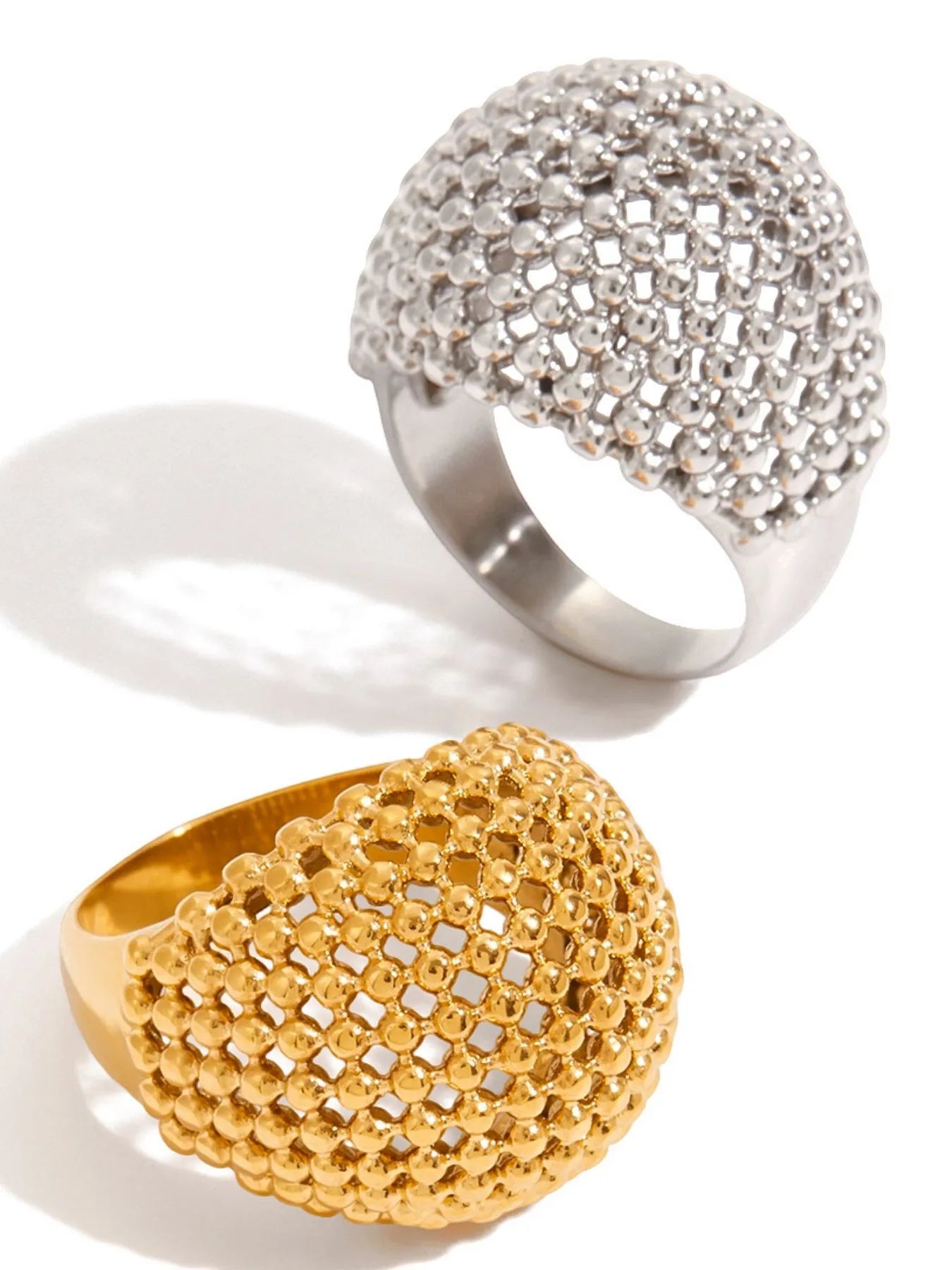 Two rings, one gold and one silver, on a white background