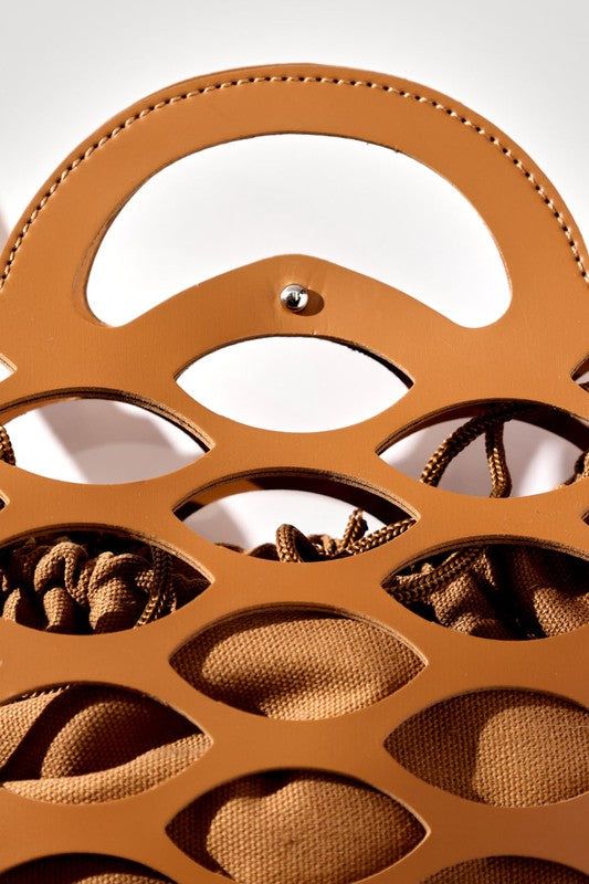 Brown leather handbag with intricate cut-out design on a white background