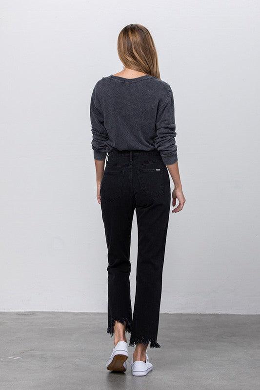 Person wearing a dark gray sweater and black pants against a plain background