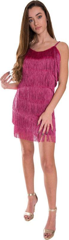 Woman wearing a pink fringe dress on a white background