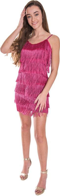 Woman wearing a pink fringe dress against a plain background