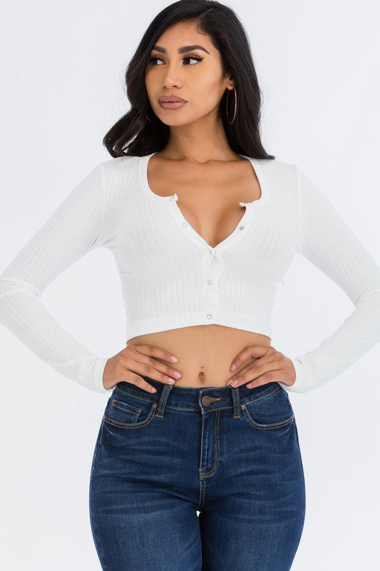 Woman wearing a white long-sleeve top and blue jeans on a white background