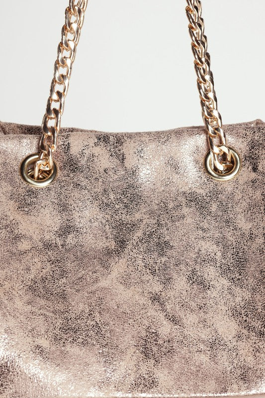 Metallic handbag with gold chain strap on a light gray background