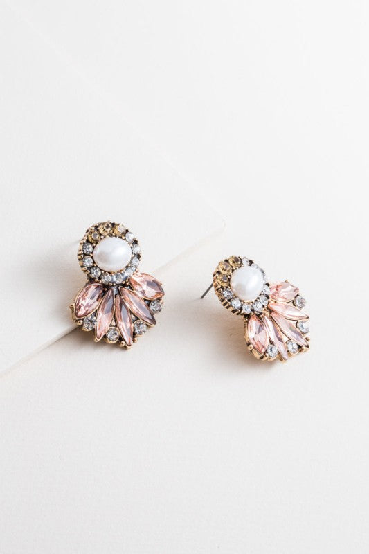 Pair of ornate earrings with pink and gold details on a light background