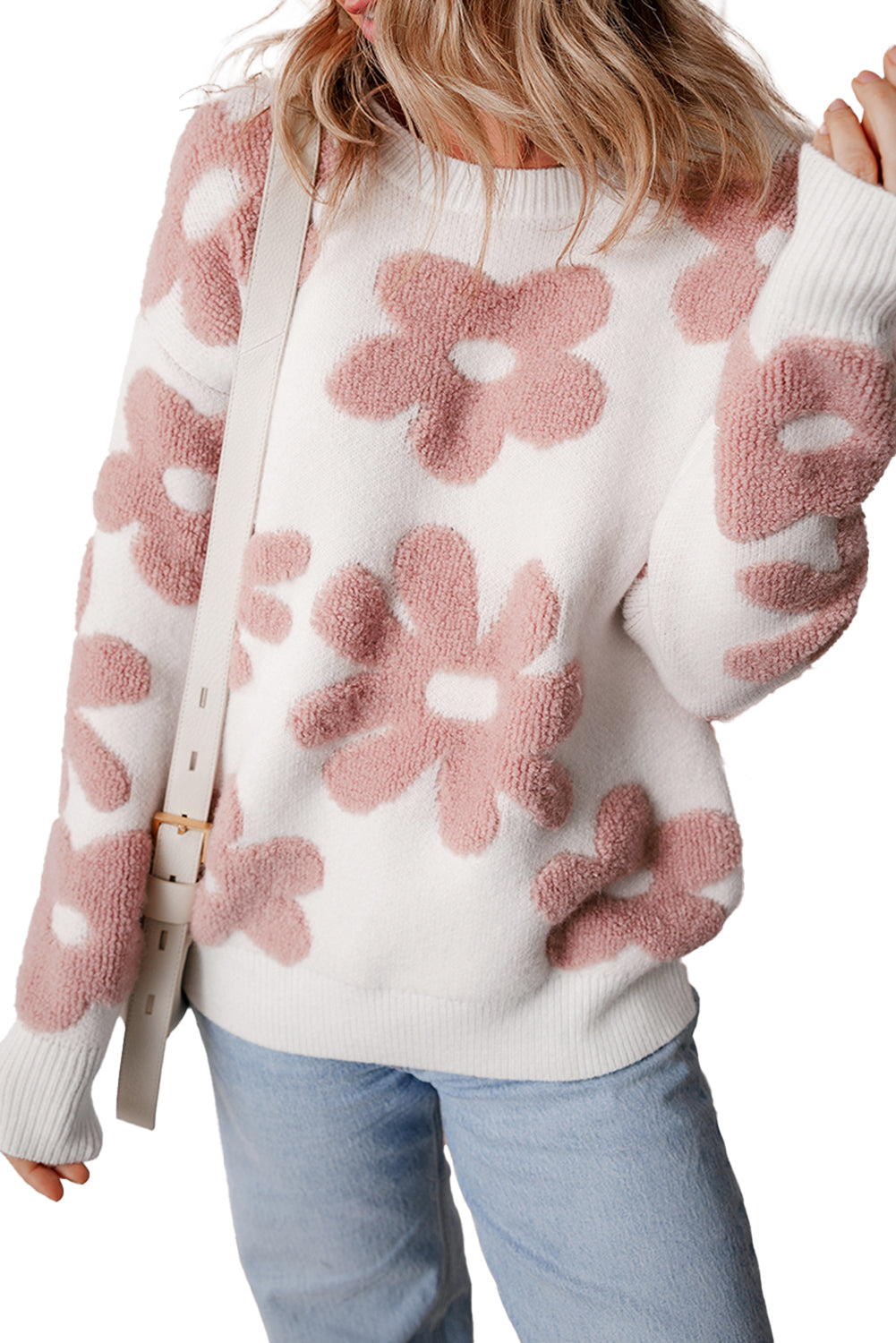 White sweater with pink floral patterns worn by a person