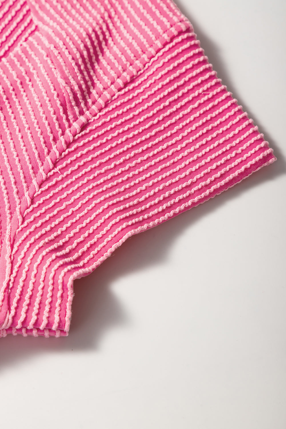 Close-up of a pink textured fabric on a light background
