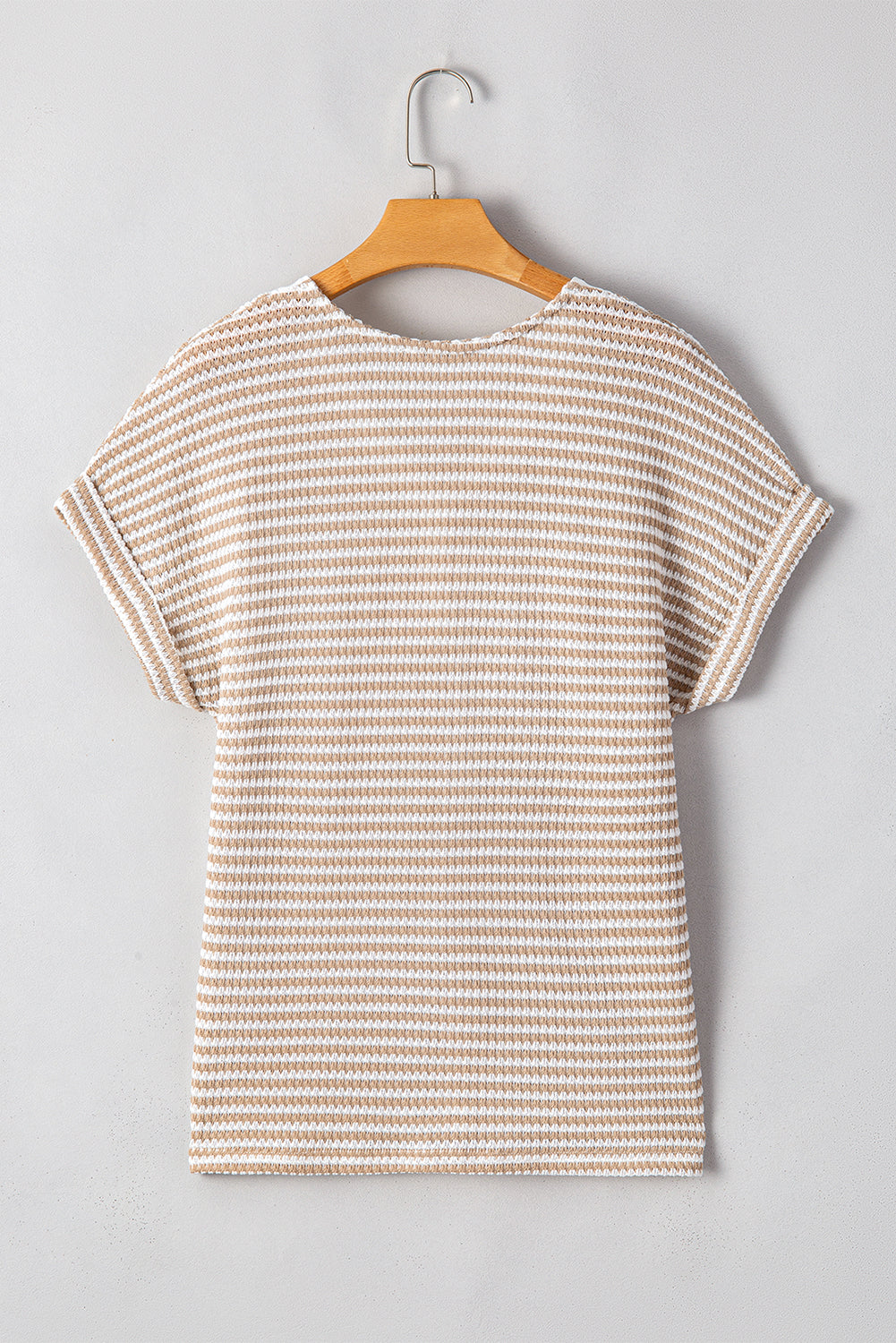 Striped t-shirt on a hanger against a gray background