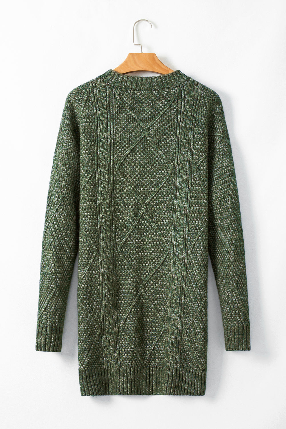 Green knitted sweater on a wooden hanger against a white background
