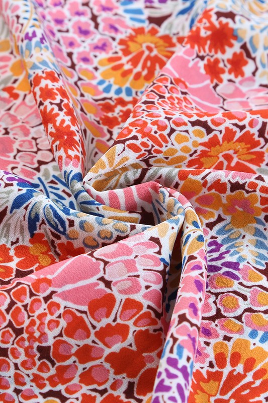 Colorful floral fabric with a pattern of pink, orange, blue, and purple.