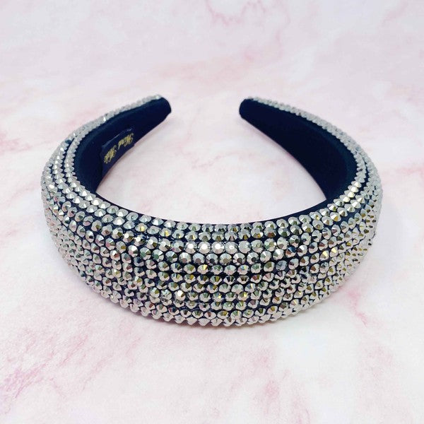 Navy headband with crystal embellishments on a pink background