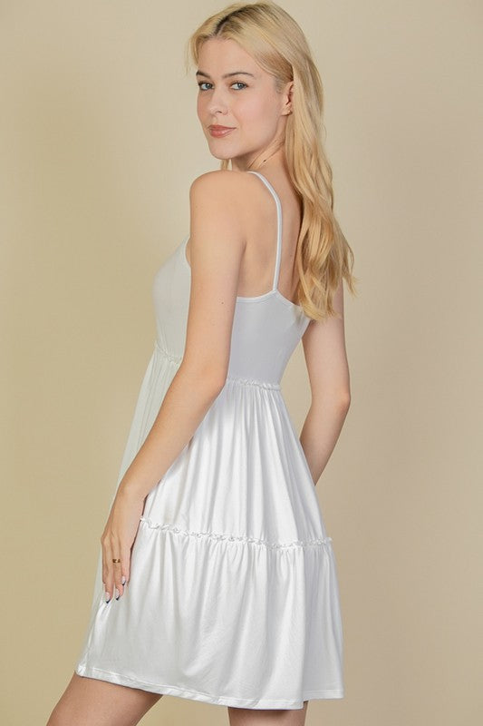 Woman wearing a white dress against a beige background