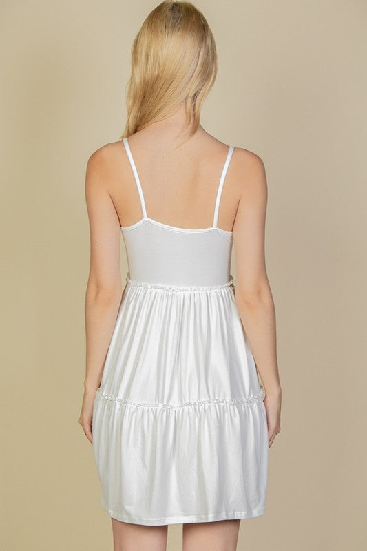 White dress worn by a person on a beige background
