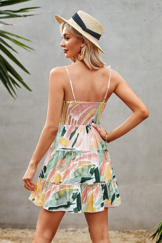 Woman wearing a colorful dress with a straw hat against a gray wall.