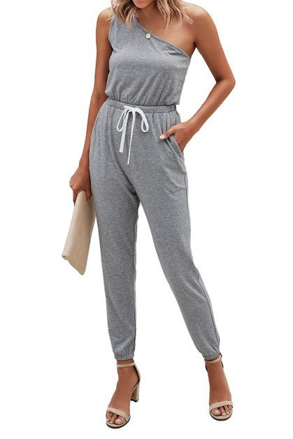 Woman wearing a gray one-shoulder jumpsuit on a white background