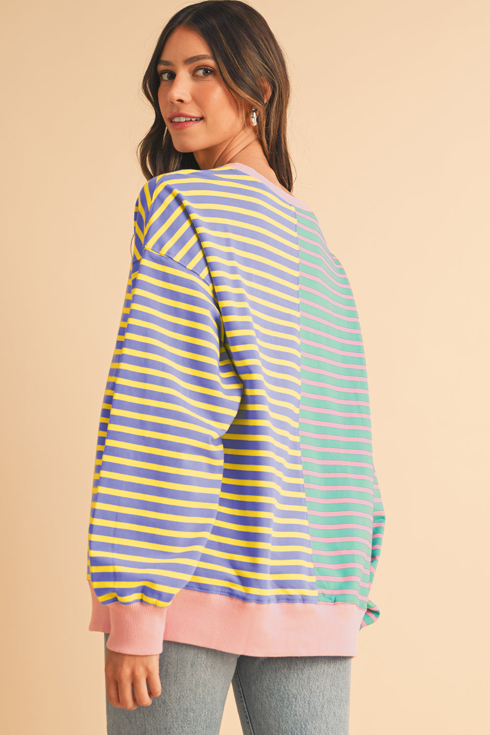 Woman wearing a striped sweater with a beige background