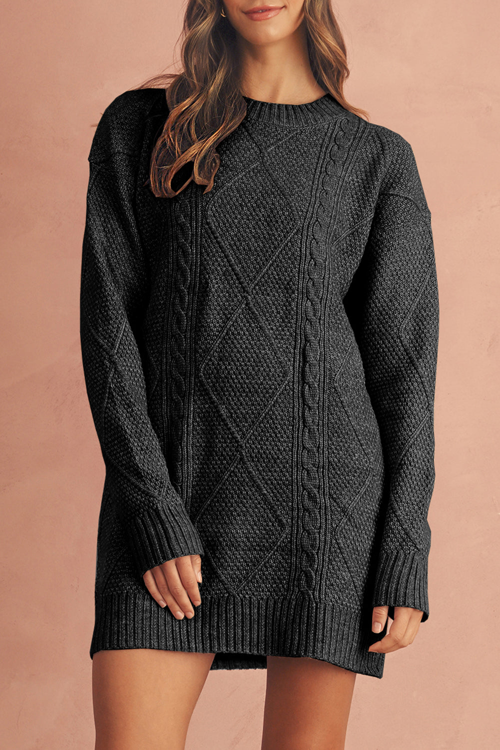 Person wearing a dark gray cable knit sweater dress against a beige background