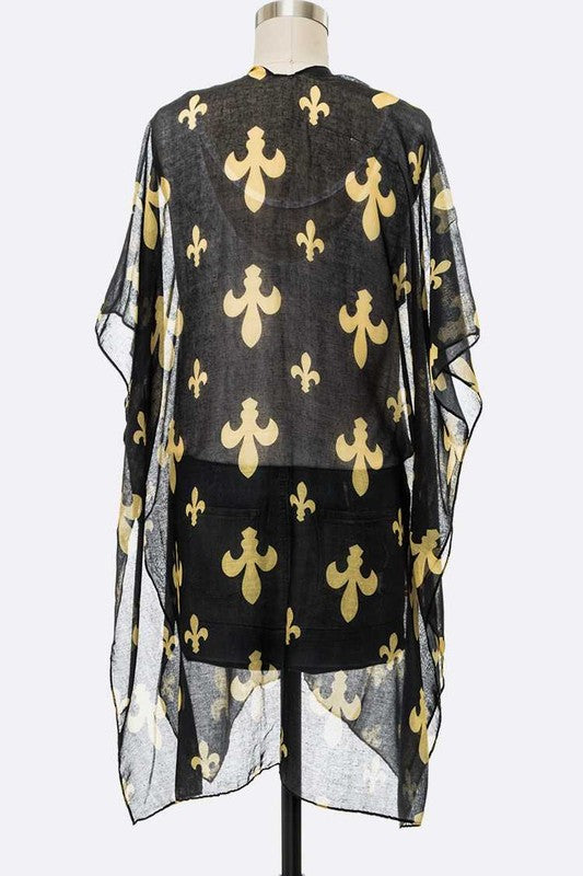 Black sheer top with gold fleur-de-lis patterns on a mannequin against a white background