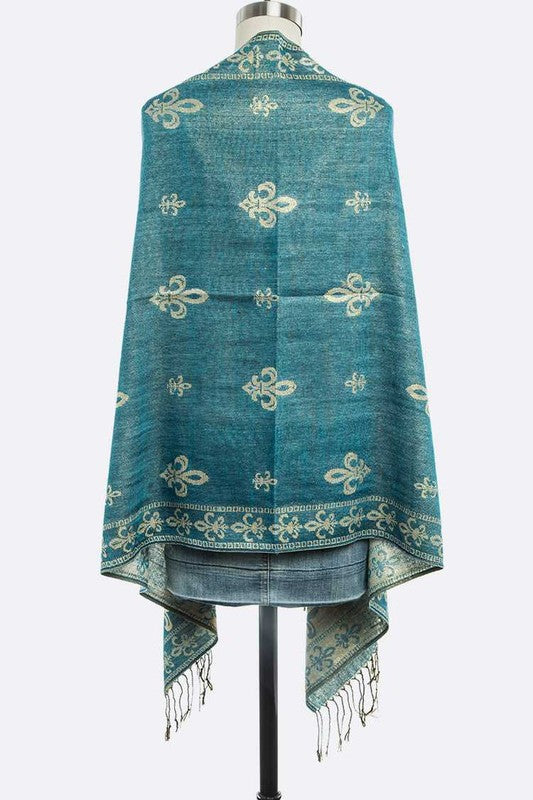 Teal shawl with white patterns on a mannequin against a white background