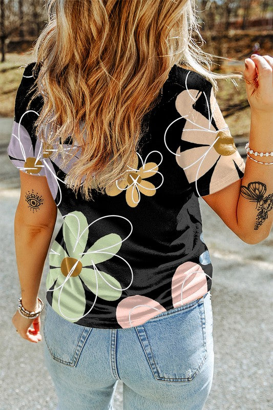 Person wearing a black tank top with floral designs outdoors