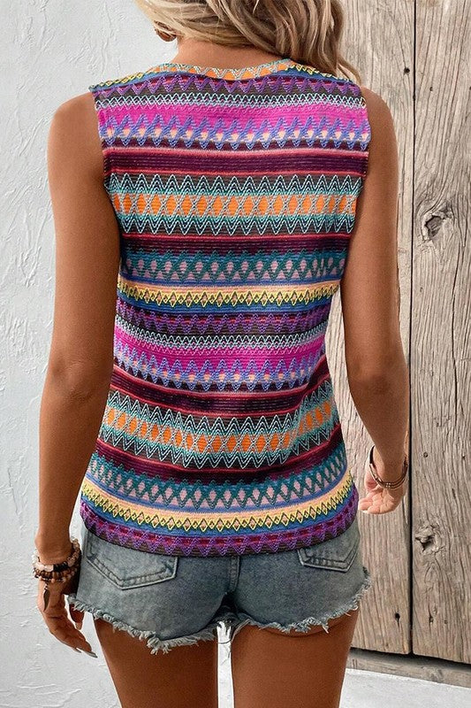 Person wearing a colorful patterned sleeveless top and denim shorts against a wooden background