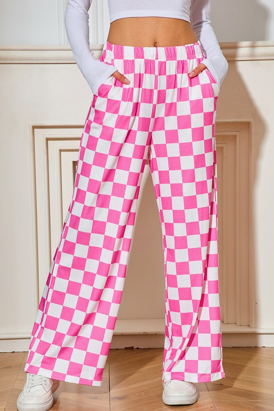 Person wearing pink and white checkered pants with a plain background
