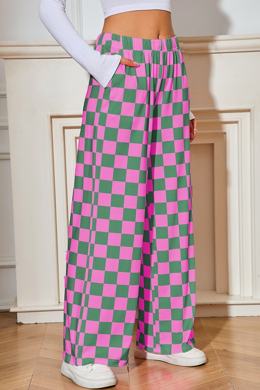 Person wearing pink and green checkered pants with a white background
